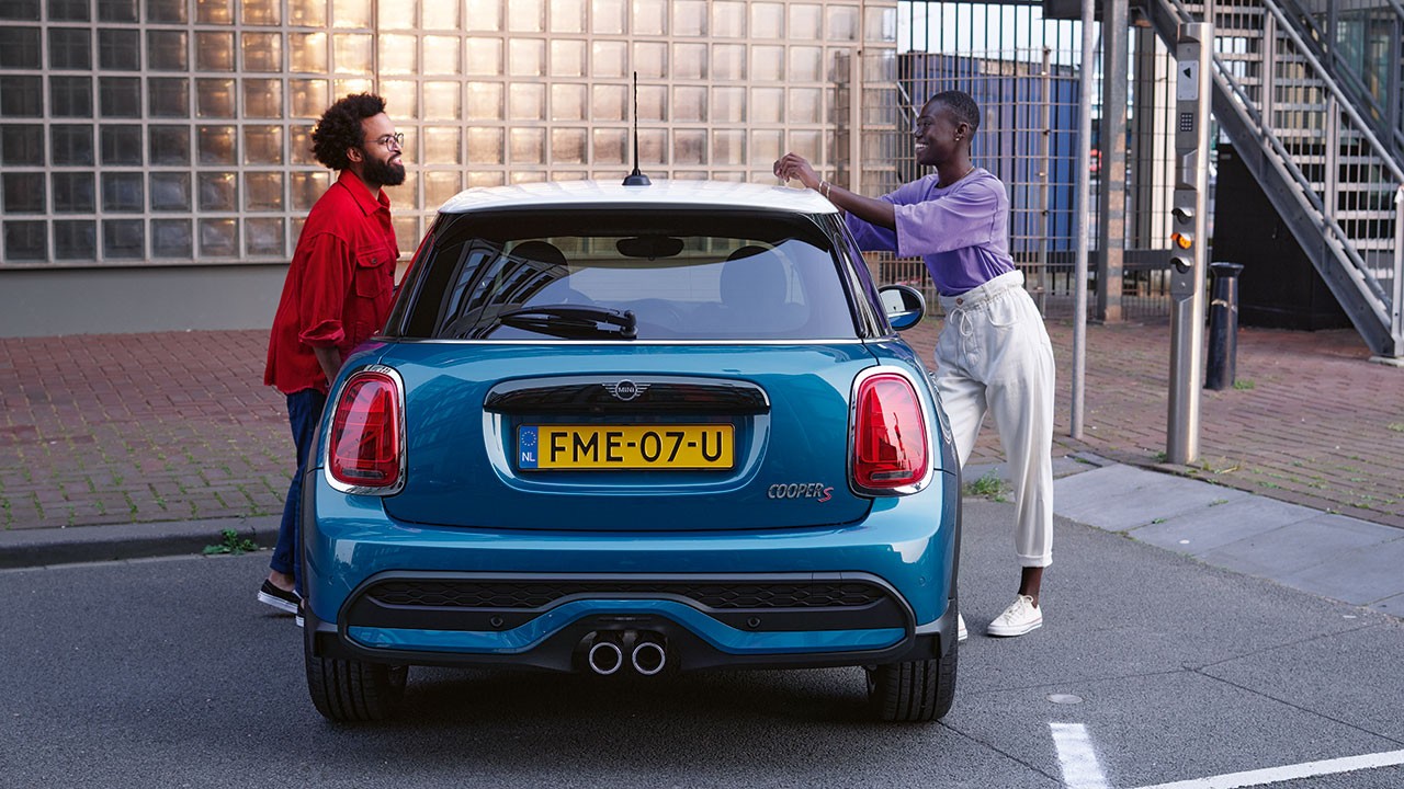 Two people standing next to MINI 3-Door Cooper S Two people standing next to MINI 3-Door Cooper S